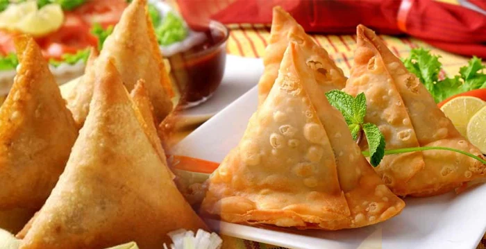 Golden samosas prepared for a party buffet